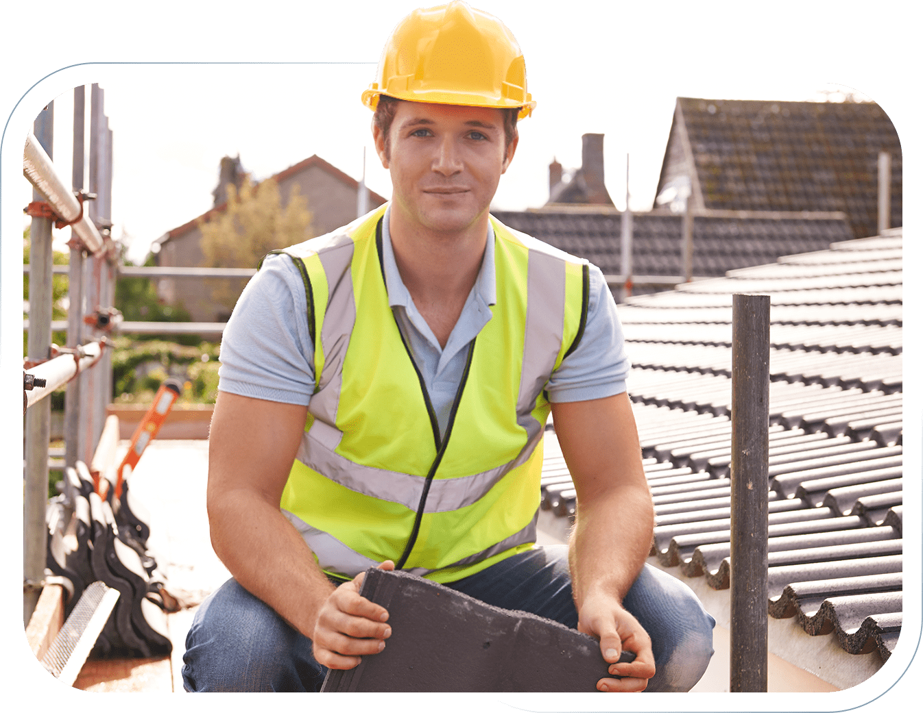 02a Construction worker in a yellow helmet and vest holding roofing material.
